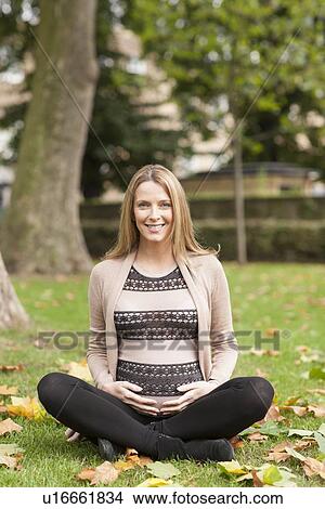 Pregnant woman sitting in park View Large Photo Image Picture - Pregnant woman sitting in park. Fotosearch