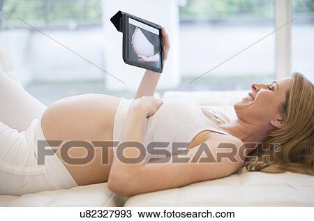 Pregnant woman using tablet computer View Large Photo Image Stock Image - Pregnant woman using tablet computer. Fotosearch
