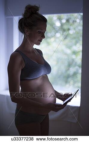 Pregnant woman using tablet computer View Large Photo Image Stock Photo - Pregnant woman using tablet computer. Fotosearch