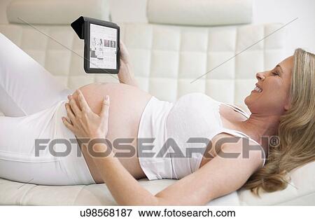 Stock Photo - Pregnant woman using tablet computer. Fotosearch