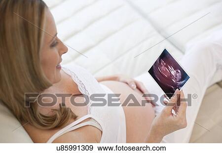 Pregnant woman with baby scan View Large Photo Image Stock Photo - Pregnant woman with baby scan. Fotosearch