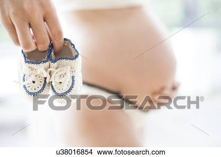 Pregnant woman with booties View Large Photo Image Picture - Pregnant woman with booties. Fotosearch