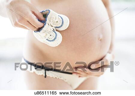 Pregnant woman with booties View Large Photo Image Stock Photography - Pregnant woman with booties. Fotosearch