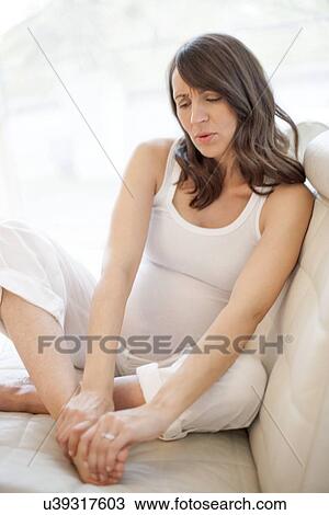 Stock Image - Pregnant woman with sore feet. Fotosearch