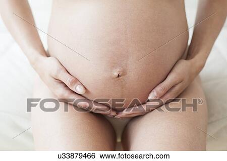 Stock Photograph - Pregnant woman's abdomen. Fotosearch