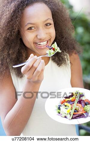 Teenage girl eating a salad View Large Photo Image Picture - Teenage girl eating a salad. Fotosearch