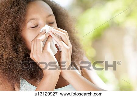 Stock Photo - Teenage girl sneezing. Fotosearch
