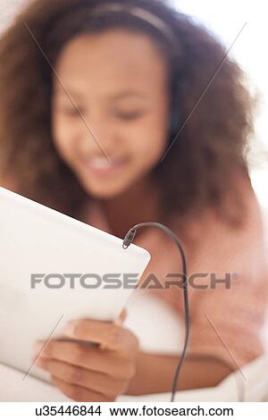 Picture - Teenage girl using a tablet computer. Fotosearch
