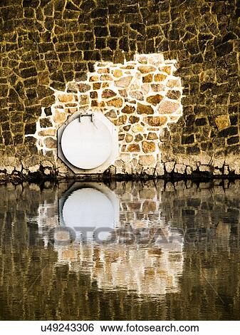 Stock Photograph - Water outlet in wall. Fotosearch