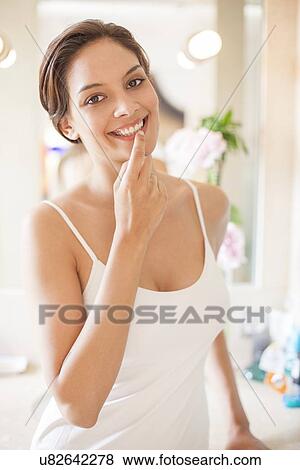 Stock Photo - Woman applying lip balm. Fotosearch