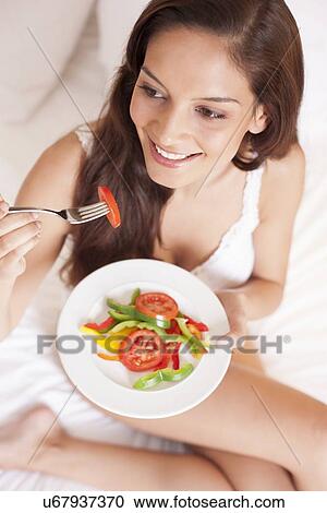 Stock Image - Woman eating a salad. Fotosearch