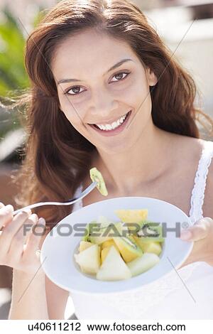 Woman eating fruit View Large Photo Image Stock Image - Woman eating fruit. Fotosearch