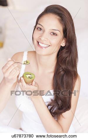 Stock Image - Woman eating fruit. Fotosearch