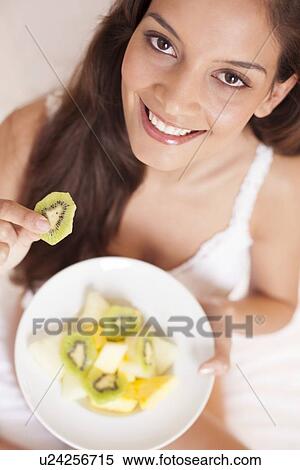 Stock Photography - Woman eating fruit. Fotosearch
