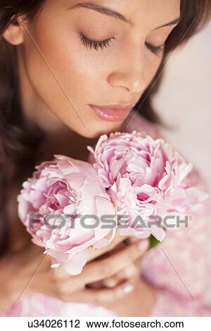Stock Image - Woman smelling flowers. Fotosearch