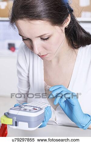 Woman using handheld machine View Large Photo Image Stock Photography - Woman using handheld machine. Fotosearch
