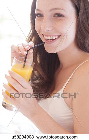 Young woman drinking fruit juice View Large Photo Image Stock Photo - Young woman drinking fruit juice. Fotosearch