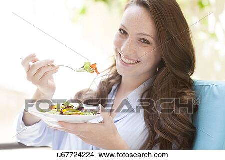 Young woman eating a salad View Large Photo Image Picture - Young woman eating a salad. Fotosearch