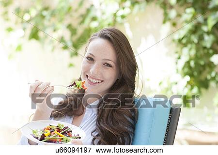 Young woman eating a salad View Large Photo Image Stock Photo - Young woman eating a salad. Fotosearch