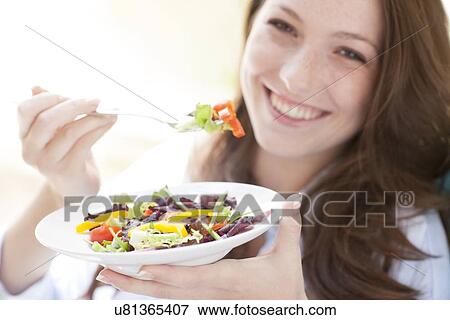 Young woman eating a salad View Large Photo Image Stock Photo - Young woman eating a salad. Fotosearch