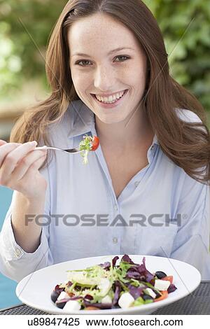 Stock Photography - Young woman eating a salad. Fotosearch