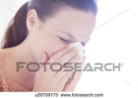 Stock Image - Young woman sneezing. Fotosearch