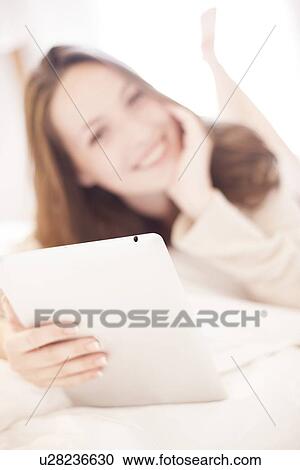 Stock Image - Young woman using a tablet computer. Fotosearch