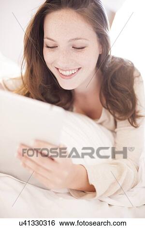 Young woman using a tablet computer View Large Photo Image Stock Photograph - Young woman using a tablet computer. Fotosearch