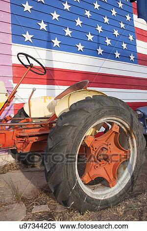 Stock Photography - Red tractor and US Flag, Seligman, Arizona. Fotosearch