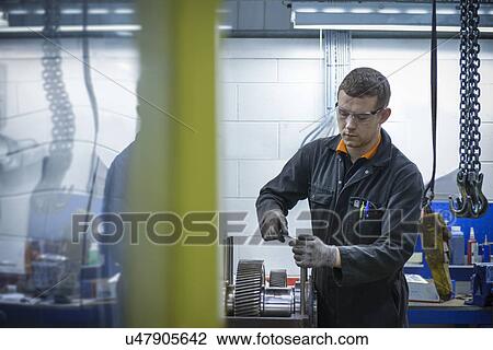 Apprentice engineer assembling industrial gearbox in factory View Large Photo Image Stock Image - Apprentice engineer assembling industrial gearbox in factory. Fotosearch