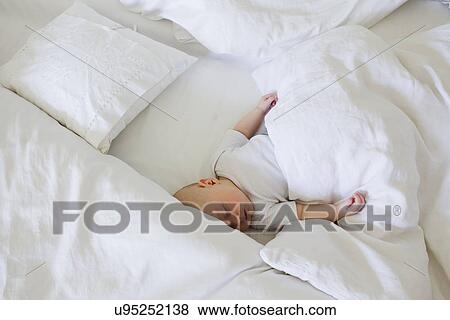 Stock Photo - Baby girl asleep in bed. Fotosearch