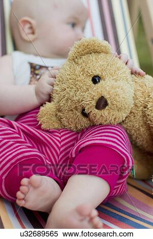 Stock Photography - Baby girl holding teddy bear. Fotosearch