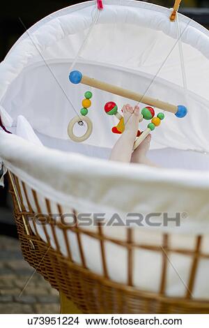 Picture - Baby girl in cot playing with mobile. Fotosearch