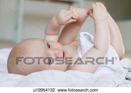 Stock Image - Baby girl lying on back. Fotosearch