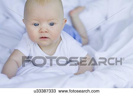 Baby girl lying on bedclothes View Large Photo Image Stock Image - Baby girl lying on bedclothes. Fotosearch