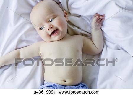 Baby girl lying on bedclothes View Large Photo Image Stock Image - Baby girl lying on bedclothes. Fotosearch