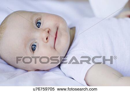 Baby girl lying on bedclothes View Large Photo Image Stock Photography - Baby girl lying on bedclothes. Fotosearch