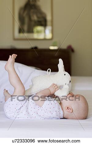 Baby girl playing with soft toy View Large Photo Image Stock Photograph - Baby girl playing with soft toy. Fotosearch