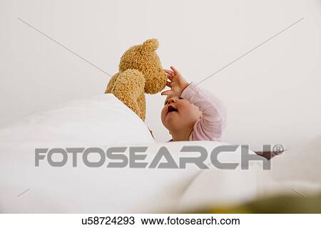Baby girl playing with teddy bear View Large Photo Image Stock Image - Baby girl playing with teddy bear. Fotosearch