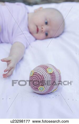 Stock Photo - Baby girl reaching for ball. Fotosearch