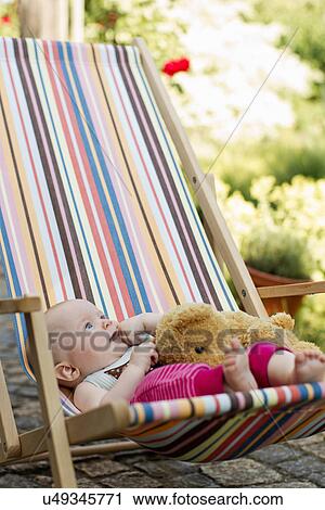 Baby girl sitting on deck chair with teddy bear View Large Photo Image Stock Image - Baby girl sitting on deck chair with teddy bear. Fotosearch