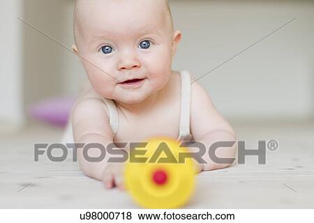 Baby girl with toy in foreground View Large Photo Image Stock Photo - Baby girl with toy in foreground. Fotosearch