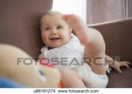 Picture - Baby playing in armchair. Fotosearch