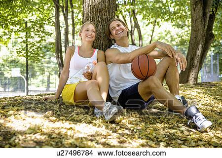 Basketball couple taking a break in park View Large Photo Image Picture - Basketball couple taking a break in park. Fotosearch