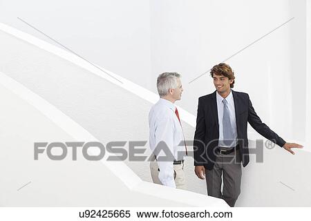 Stock Photography - Business colleagues holding meeting on stairs. Fotosearch