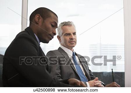 Stock Photo - Business colleagues holding meeting. Fotosearch