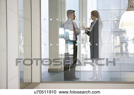 Business colleagues in discussion through glass View Large Photo Image Stock Image - Business colleagues in discussion through glass. Fotosearch