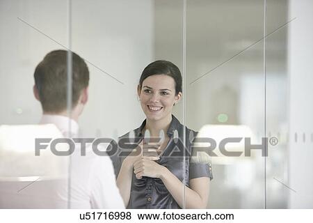 Stock Photo - Business colleagues in discussion through glass. Fotosearch