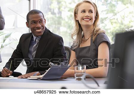 Business colleagues smiling at meeting View Large Photo Image Stock Photography - Business colleagues smiling at meeting. Fotosearch