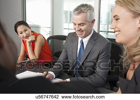 Stock Image - Business manager and colleagues holding meeting. Fotosearch